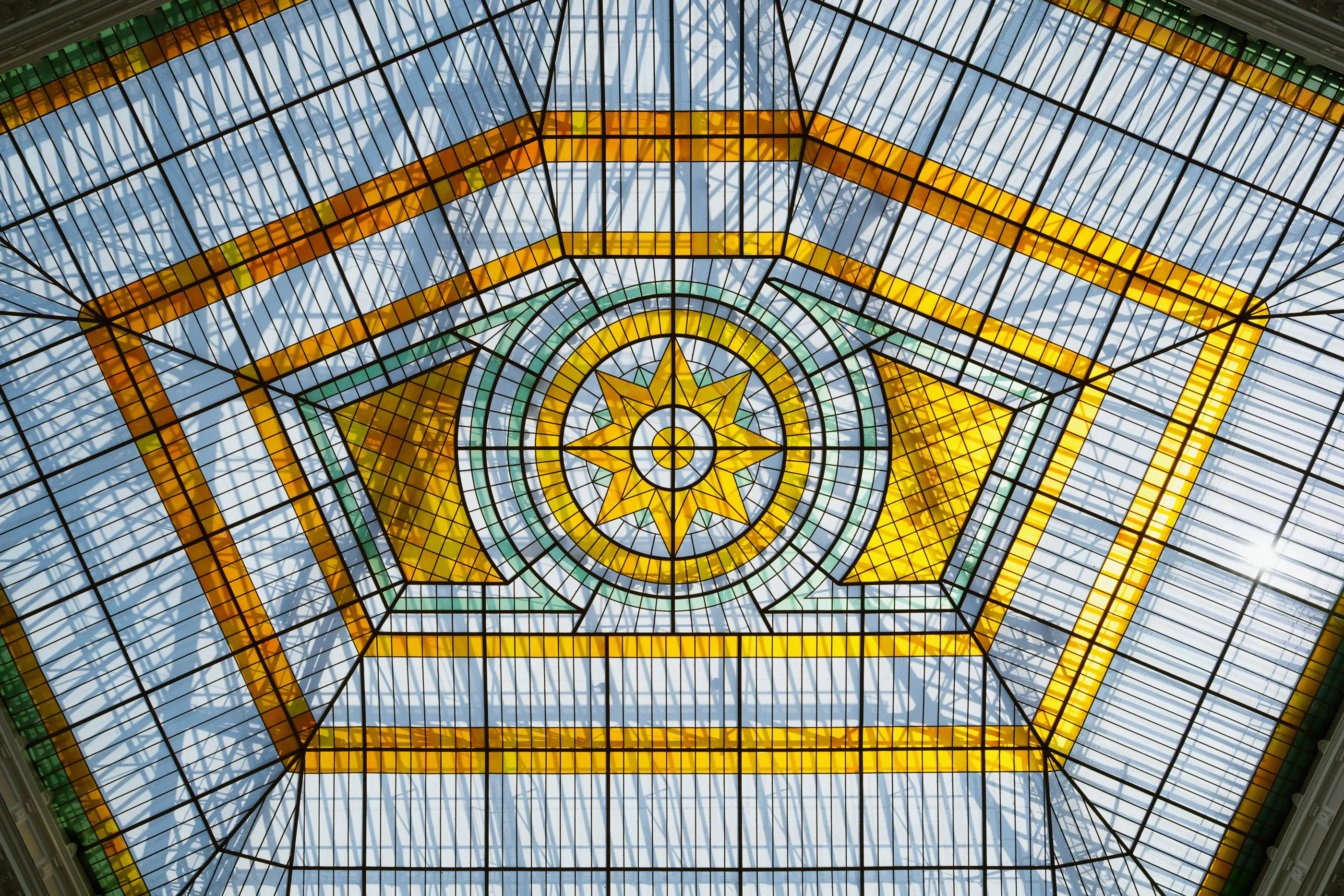 An ornate Art Nouveau stained-glass dome with a radiating star motif, Warsaw University of Technology.